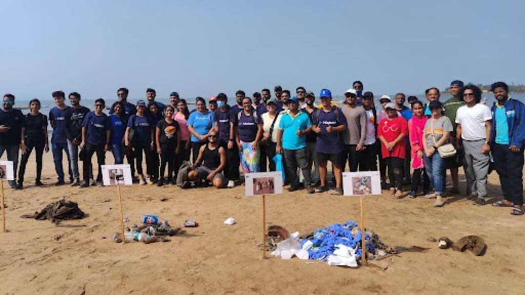 해변에서 쓰레기를 수거하며 포즈를 취하고 있는 자원봉사자 그룹